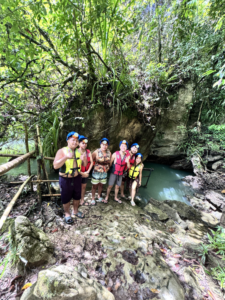 travelers taking a picture before going in tayangban cave pool